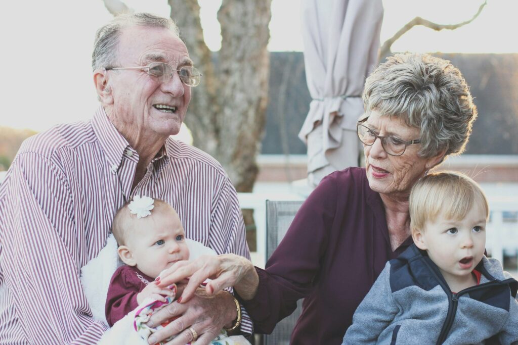 An old couple with their grand children who have planned their inheritance tax and estate planning through a trusted chartered financial adviser in Informed Financial Planning